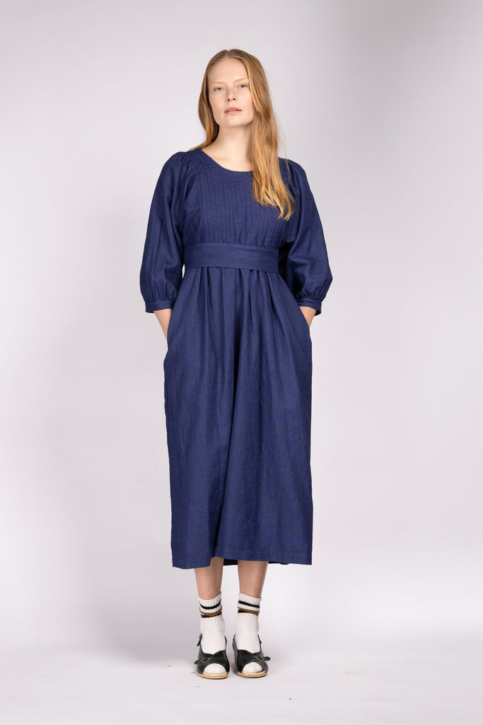 Model wears Quilt Dress from sustainable fashion brand THE REGULAR in 'workwear blue' colour