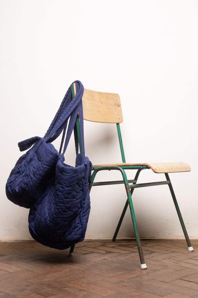 Midi and Supersized Quilty Tote from THE REGULAR slung over back of wooden chair